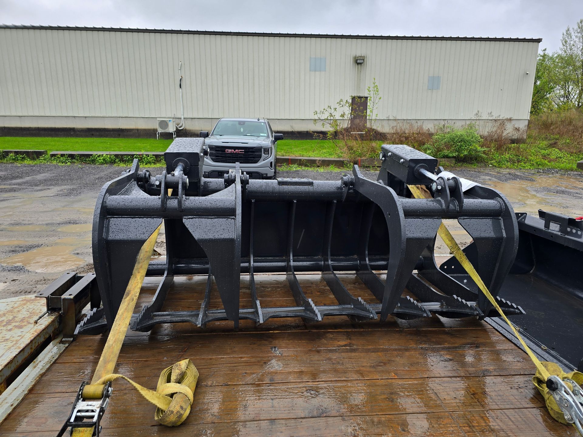 A large bucket is sitting on top of a trailer.