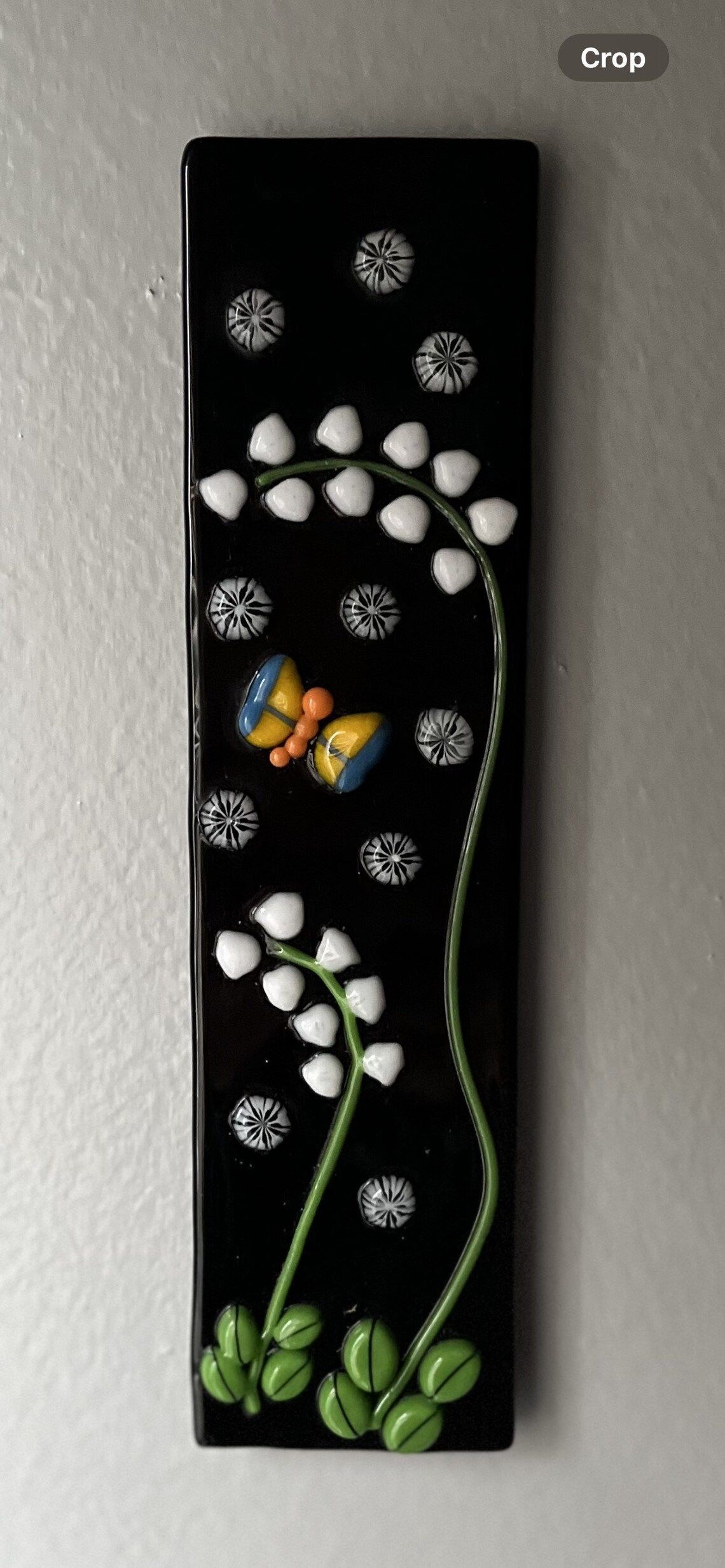 A picture of a lily of the valley with a butterfly on it