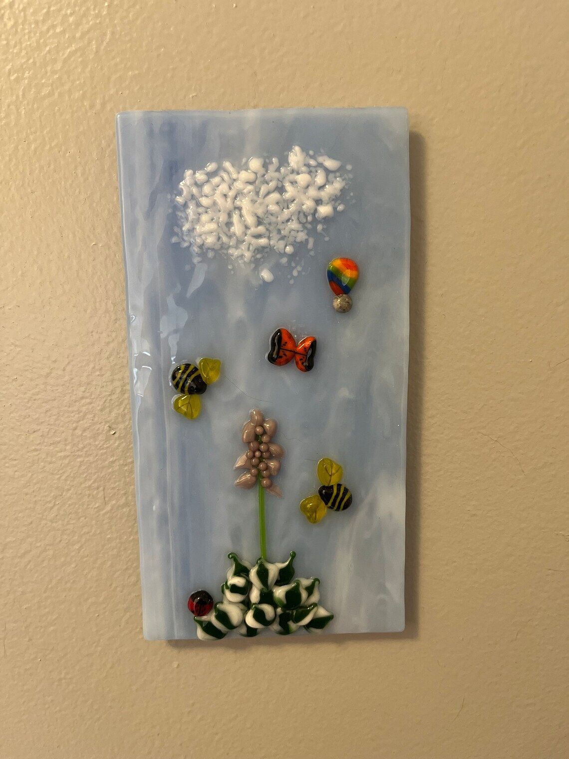 A painting of a flower and bees on a wall.