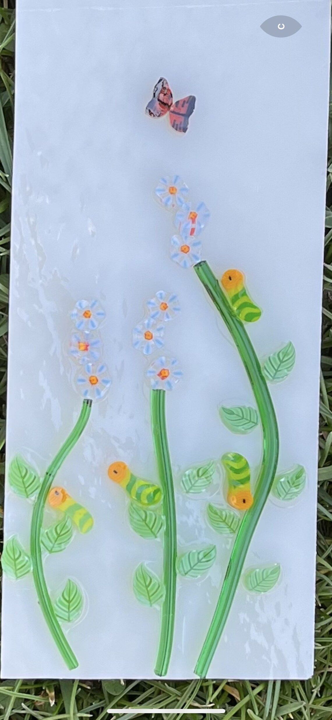 A child 's drawing of flowers and a butterfly on a piece of paper.