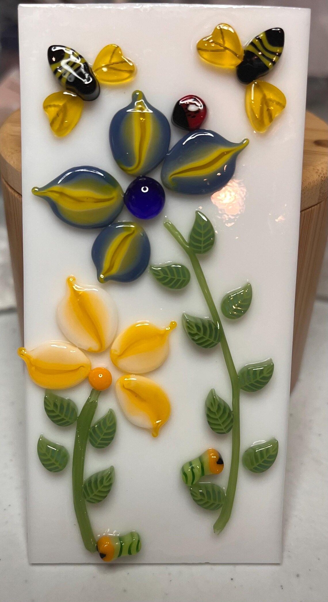 A picture of a flower with bees and leaves on it.