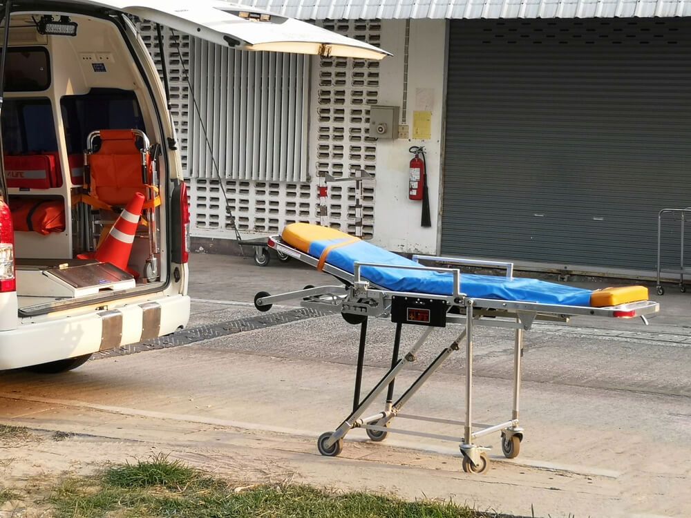 An Ambulance With a Stretcher Attached to It is Parked in Front of a Building — AVI Protection Group Pty Ltd in Tuncurry-Forster, NSW