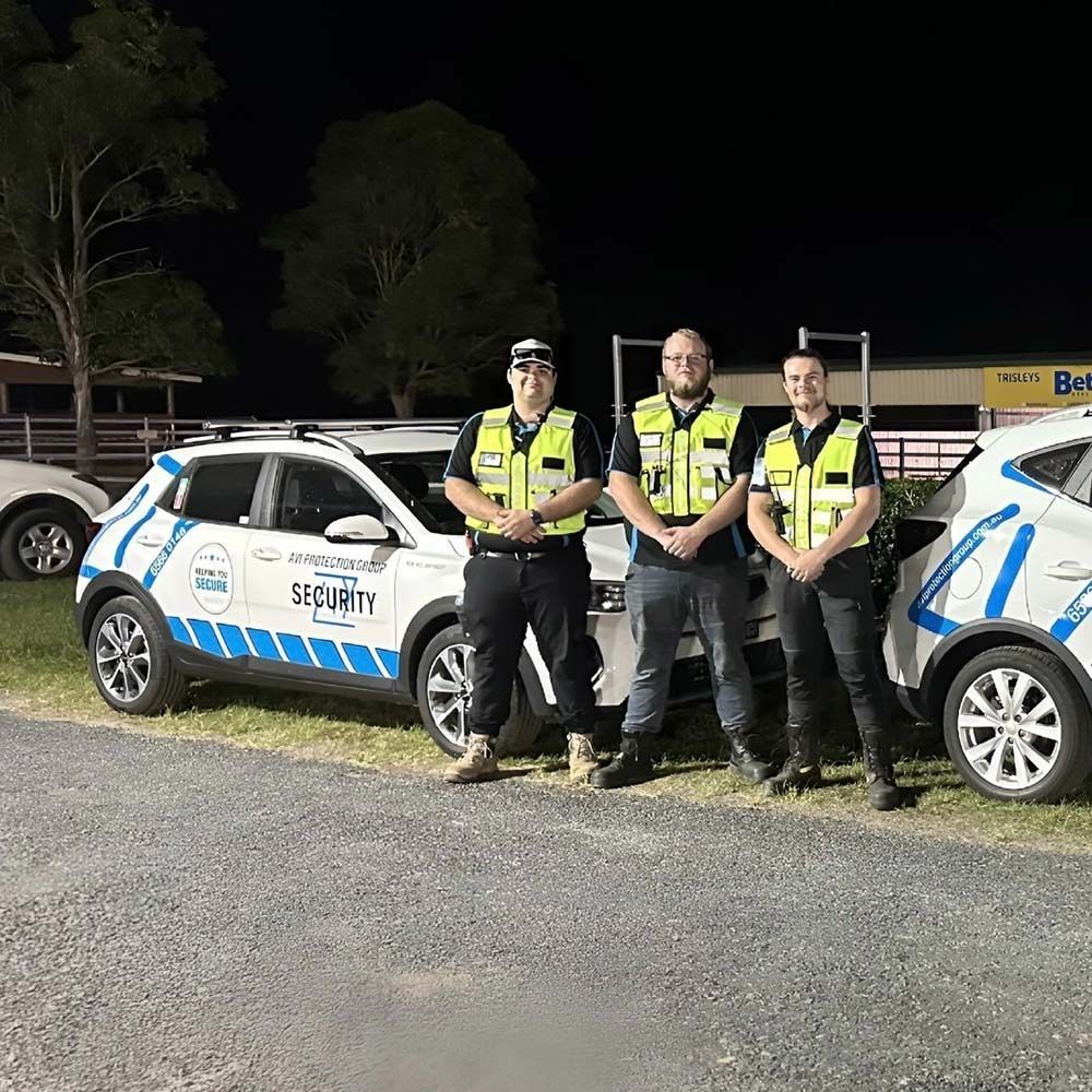 A Group of Men are Standing Next to Each Other in Front of a Car — AVI Protection Group Pty Ltd in West Kempsey, NSW