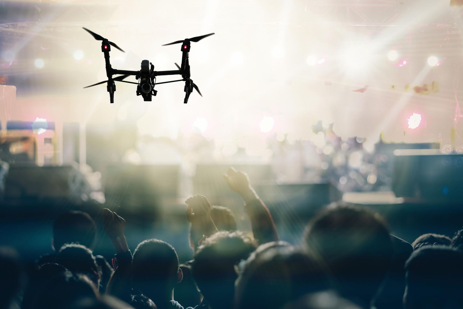 A drone is flying over a crowd of people at a concert.