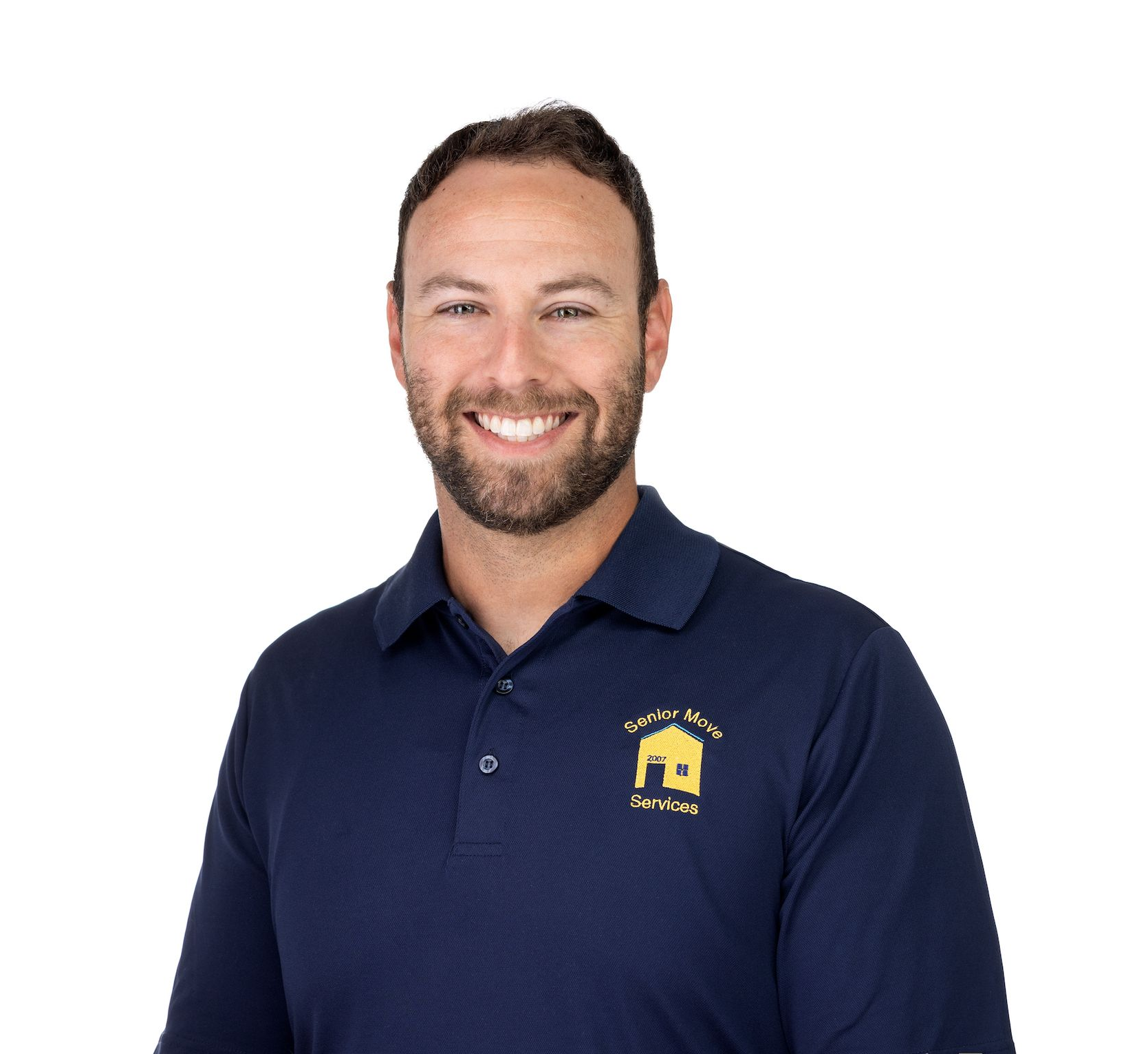 Man wearing a navy polo shirt with logo smiling.