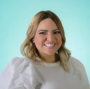 A woman in a white shirt is smiling for the camera.