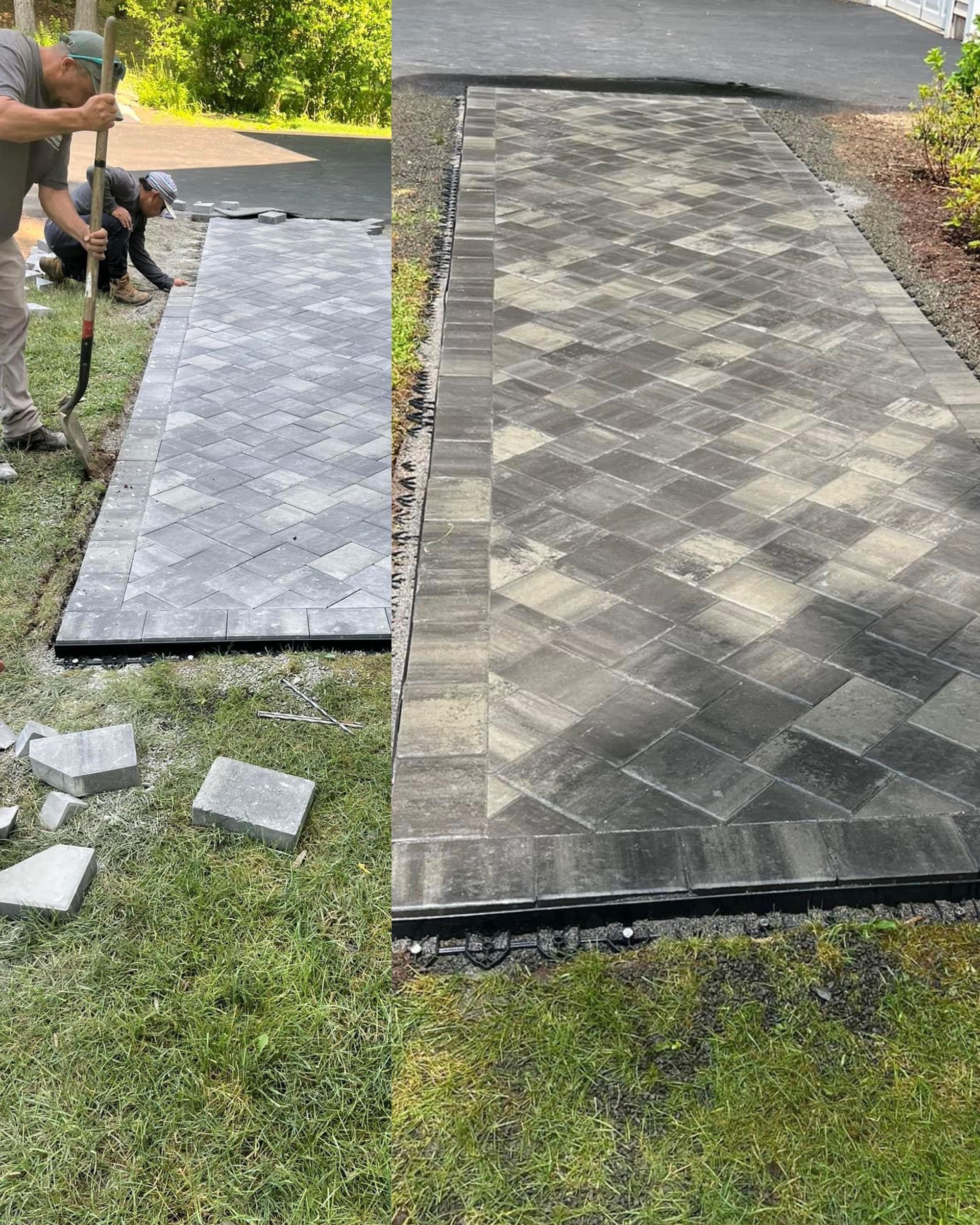 A man is laying bricks on a sidewalk in the grass.
