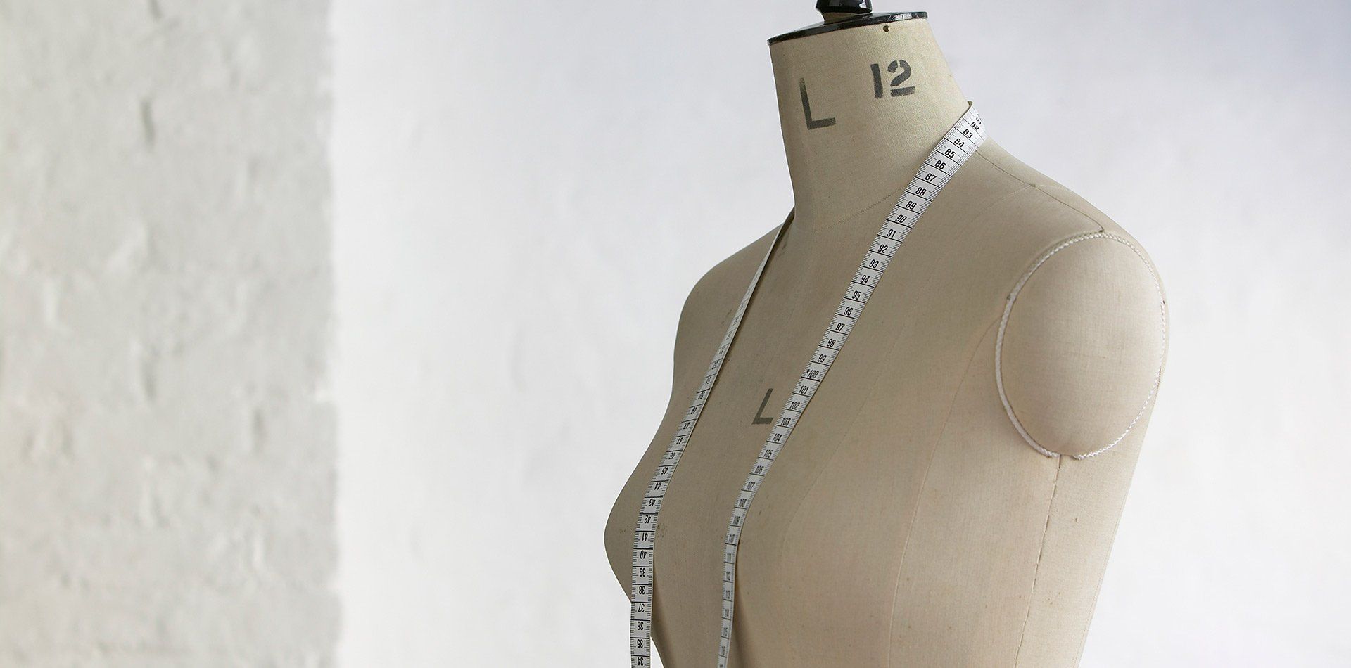unclothed mannequin with tape measure draped around neck 