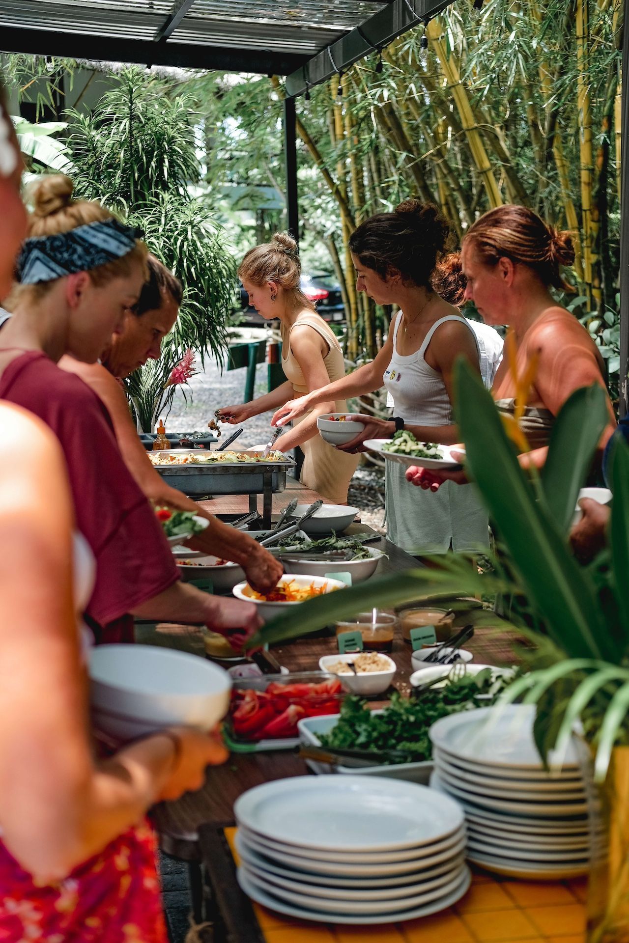 A group of women are standing around a table with plates of food.