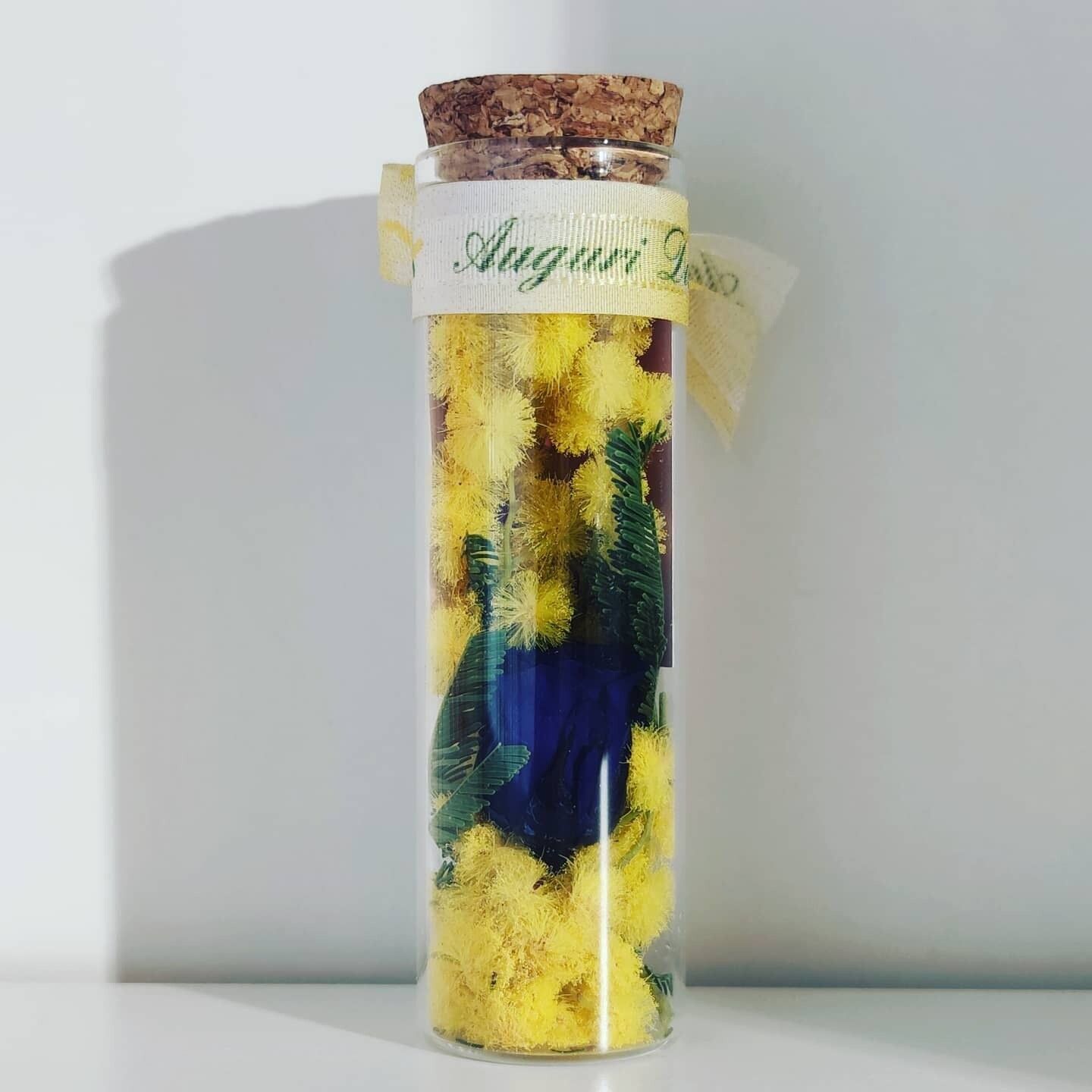 Mimosa in bottiglia con rosa preservata