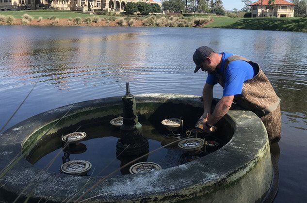 Man Fixing Lake Fountain — Jacksonville, FL — Innovative Fountain Services