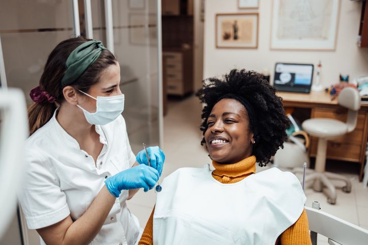 A dentist is looking at an x-ray of a patient 's teeth.