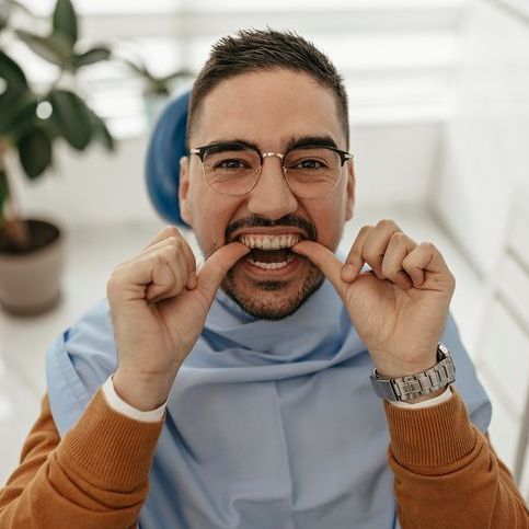 man putting on clear aligner