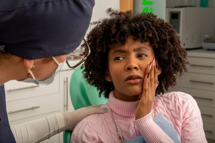 A man is sitting in a dental chair with a toothache.