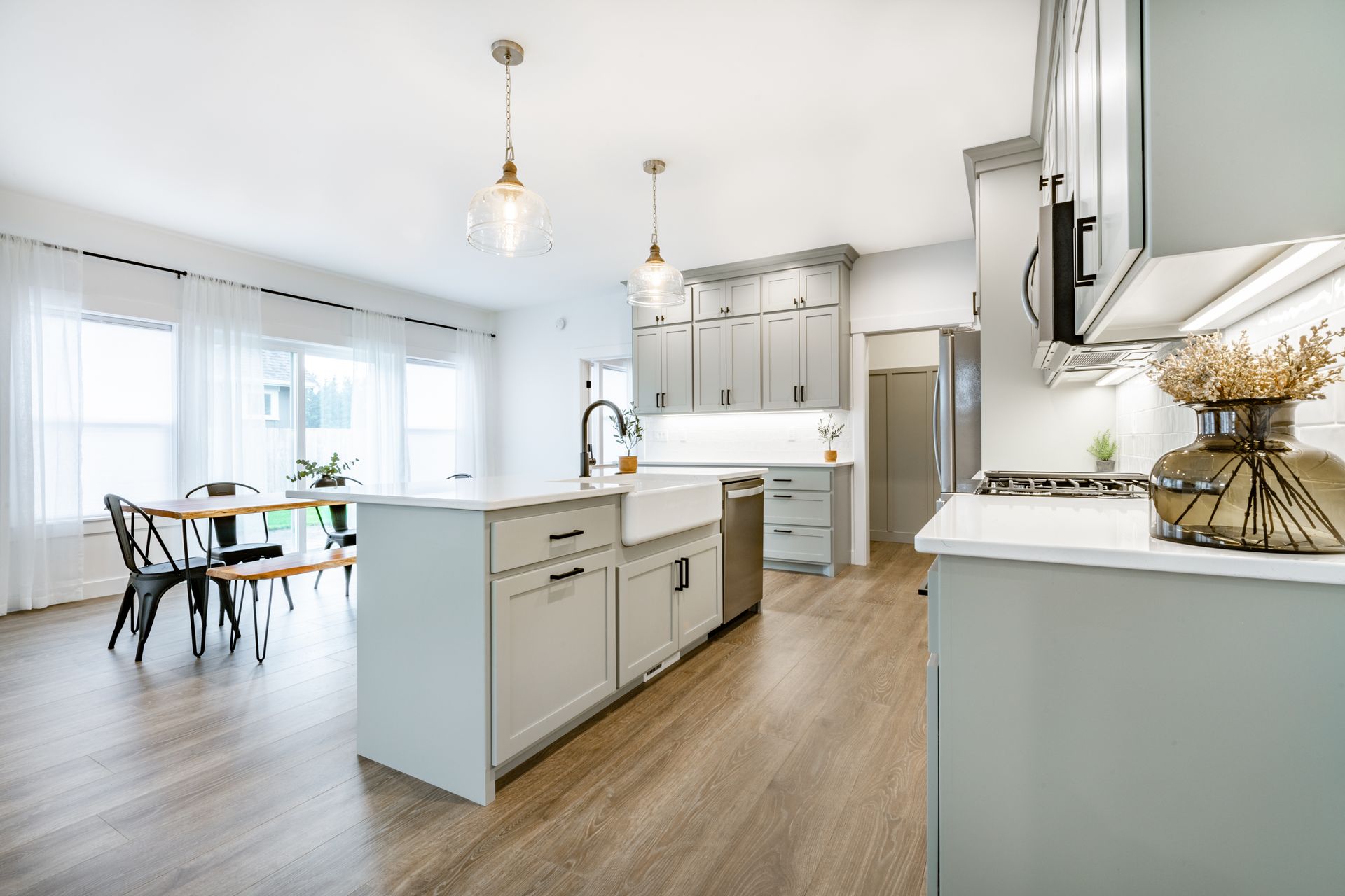 A kitchen with a large island and a dining room in the background.