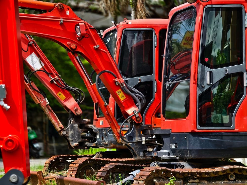 A large yellow excavator is demolishing a building.