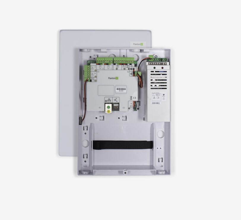 A smart device is sitting on a wall next to a plant.