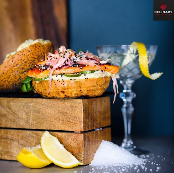 Ein Sandwich liegt auf einer Holzkiste neben Zitronenscheiben