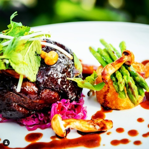 Ein Teller mit Essen mit Spargel und Pilzen darauf