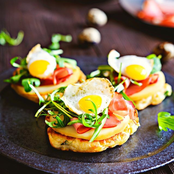 Ein Teller mit Essen mit Eiern und Schinken darauf