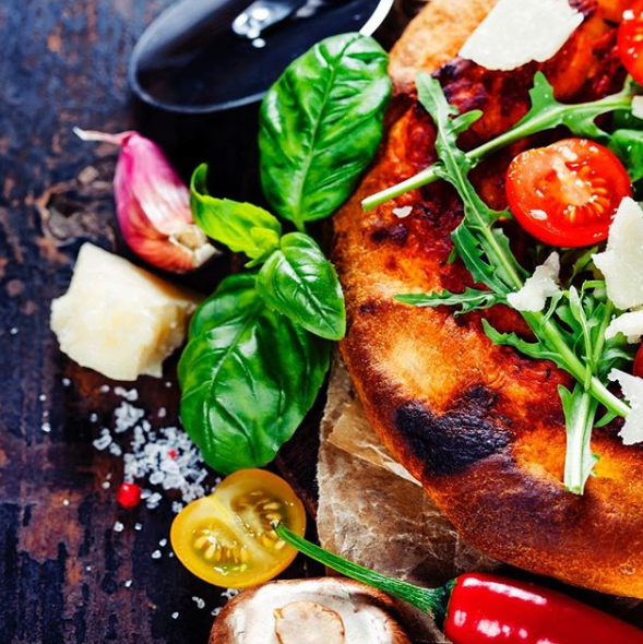 Eine Pizza mit Tomaten, Basilikum und Käse darauf