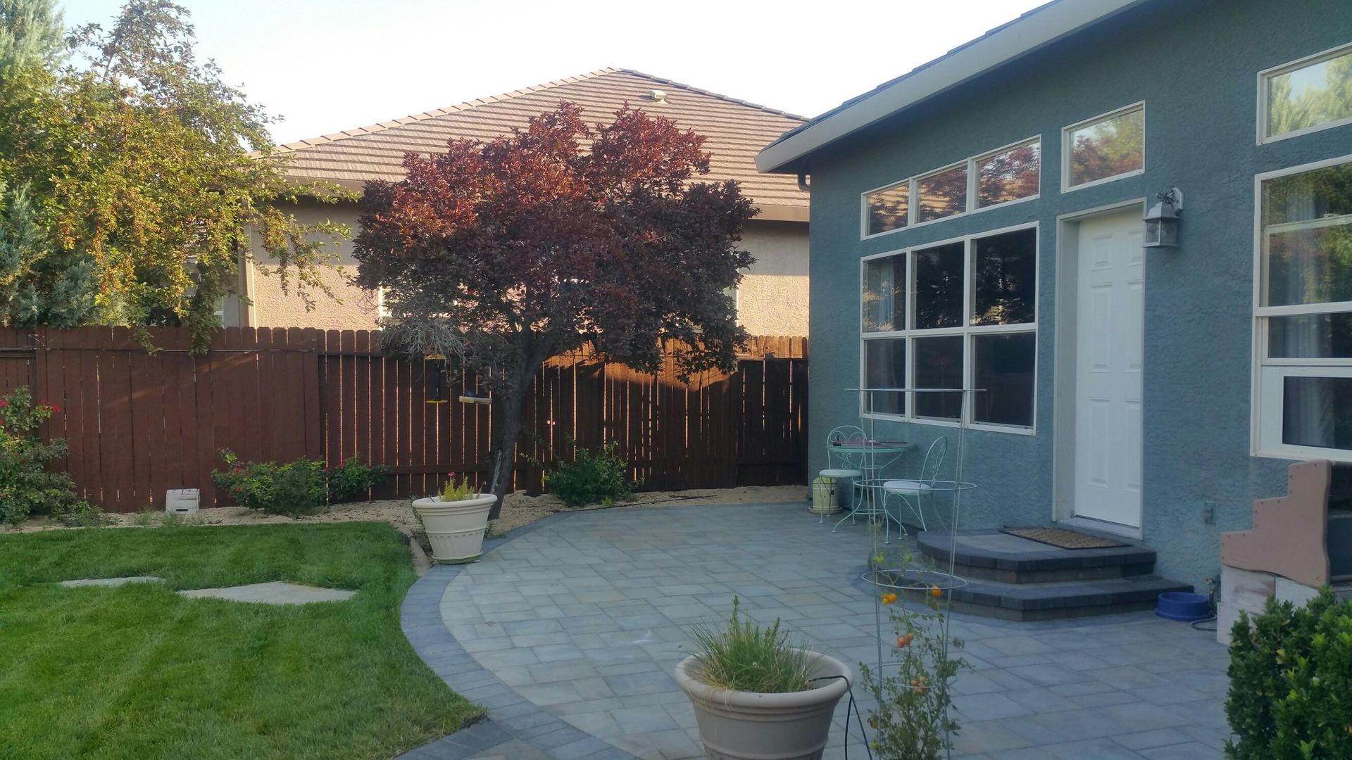 A house with a patio and a tree in front of it