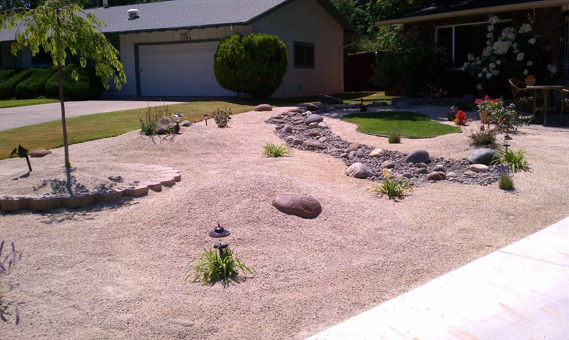 A gravel yard with a house in the background