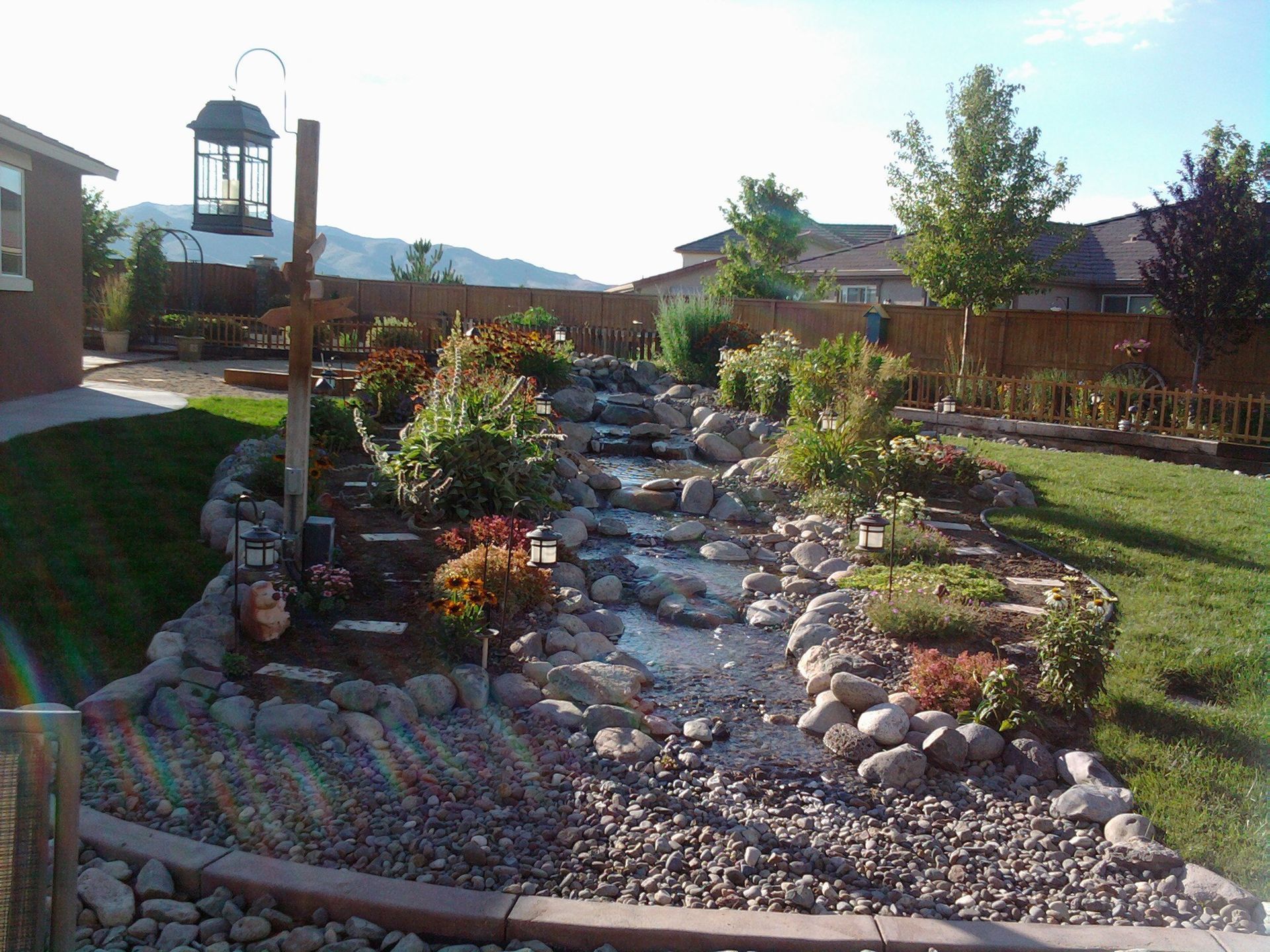 A backyard with a waterfall and a bird feeder