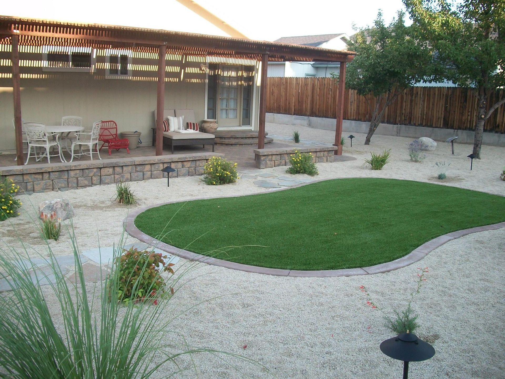 A backyard with a pergola and a large grassy area