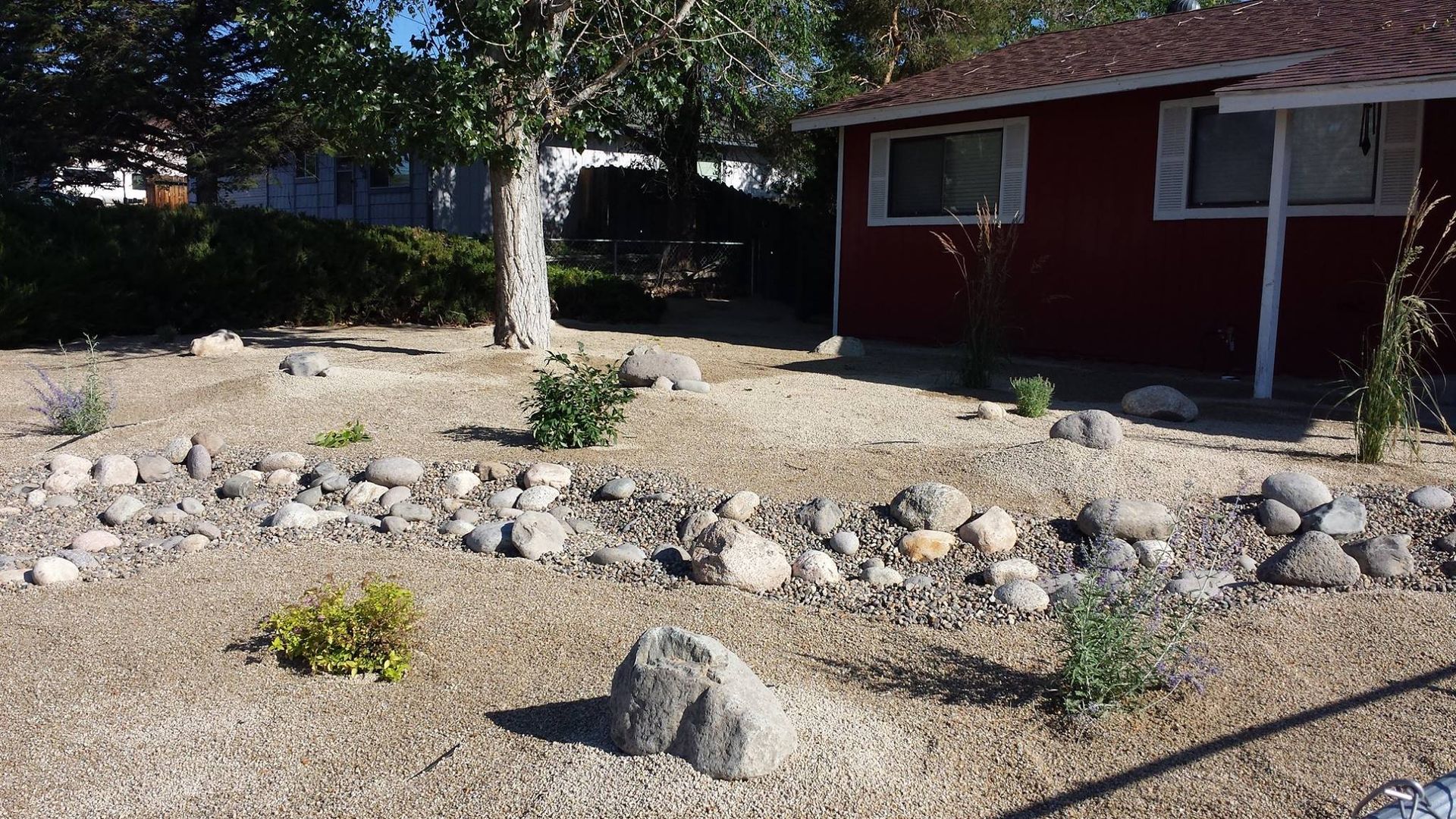 A red house with a lot of rocks in front of it