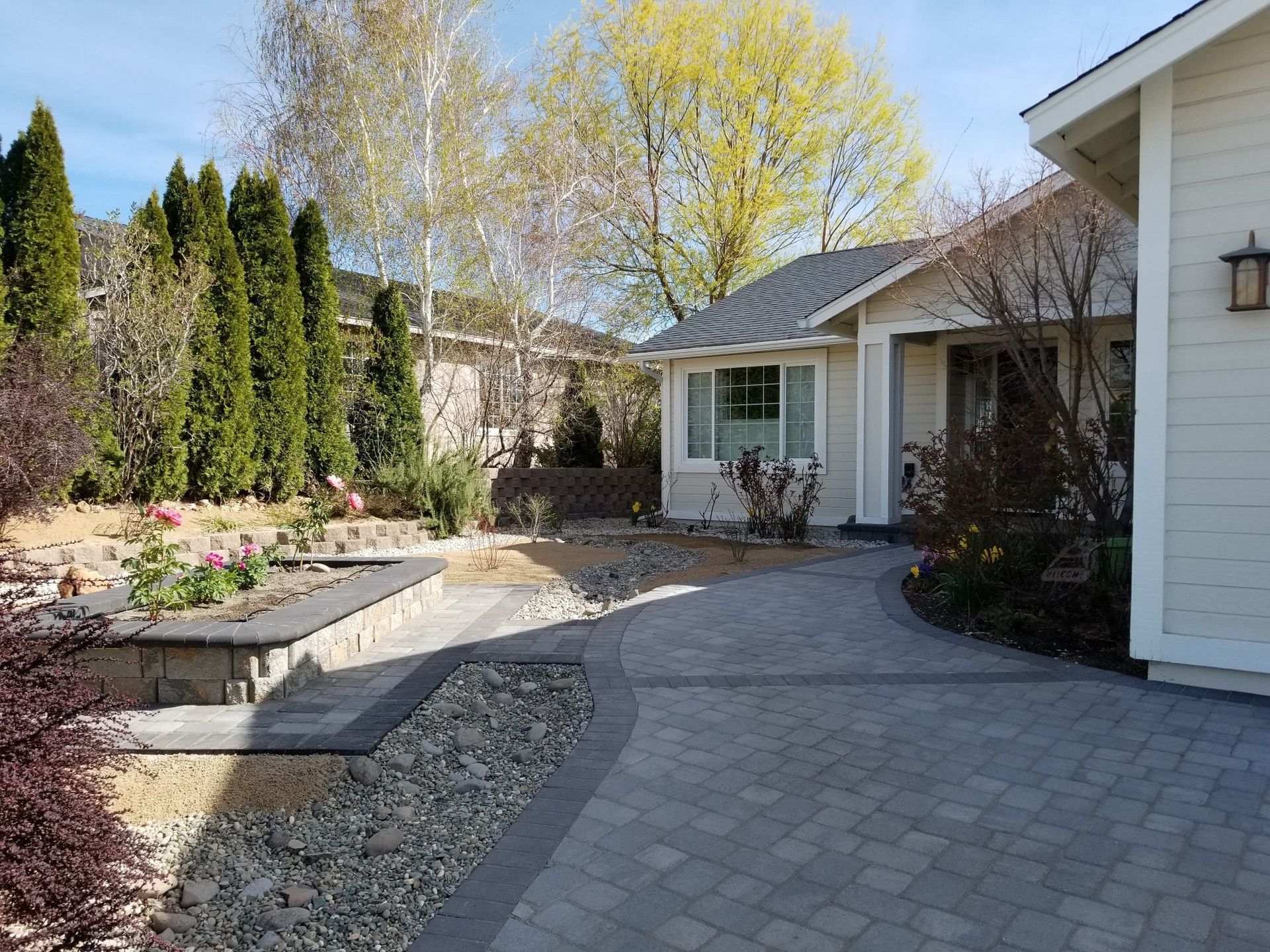 A white house with a brick driveway leading to it.