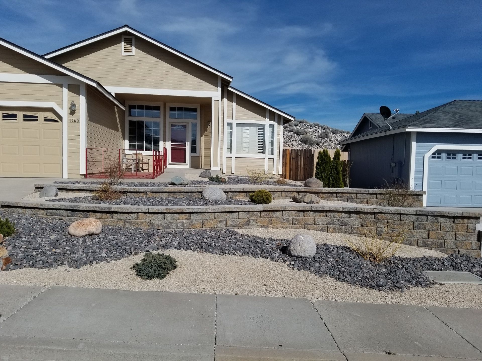 A house with a stone wall in front of it