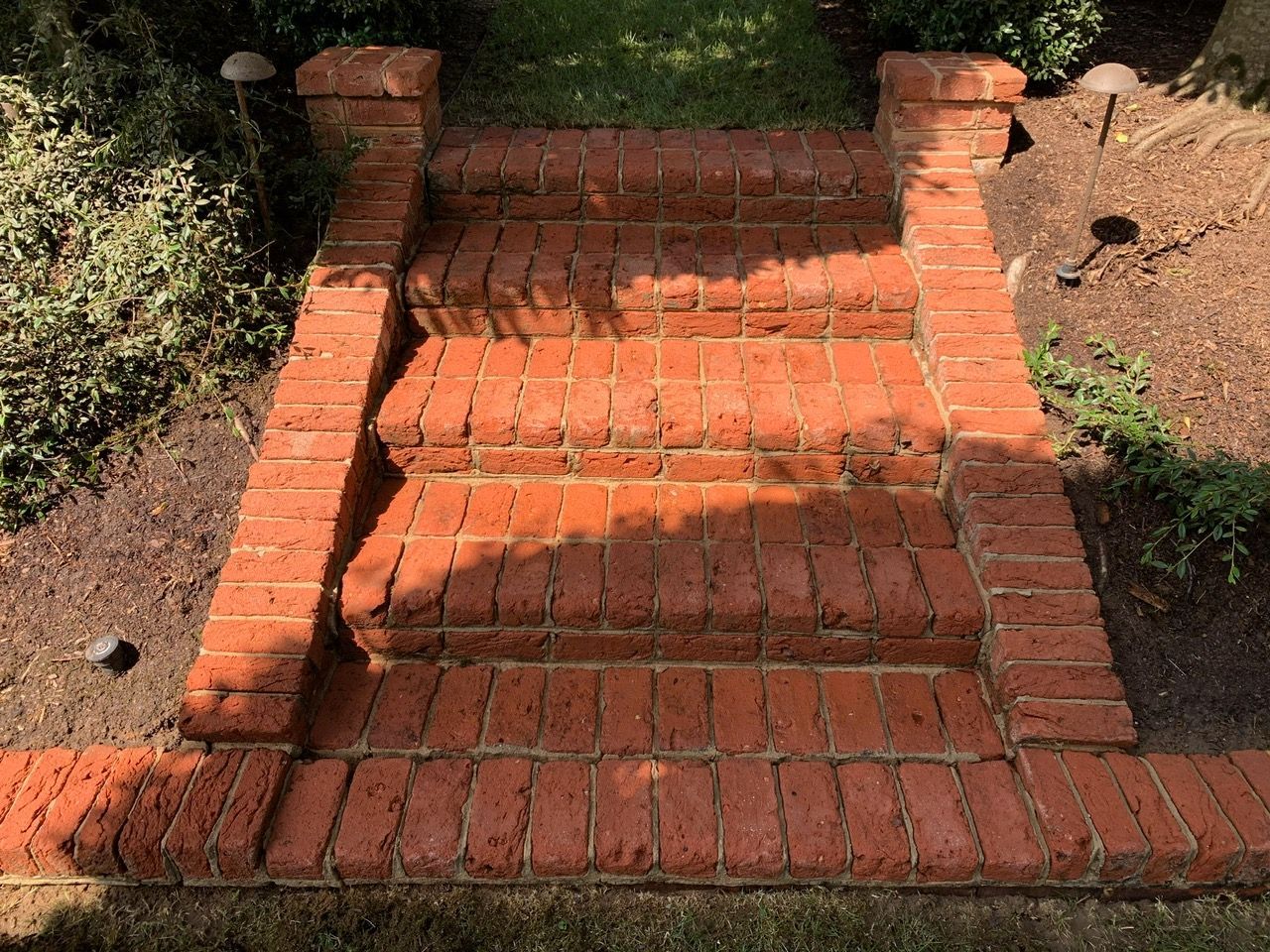 Person in boots washing a concrete floor with water and soap.