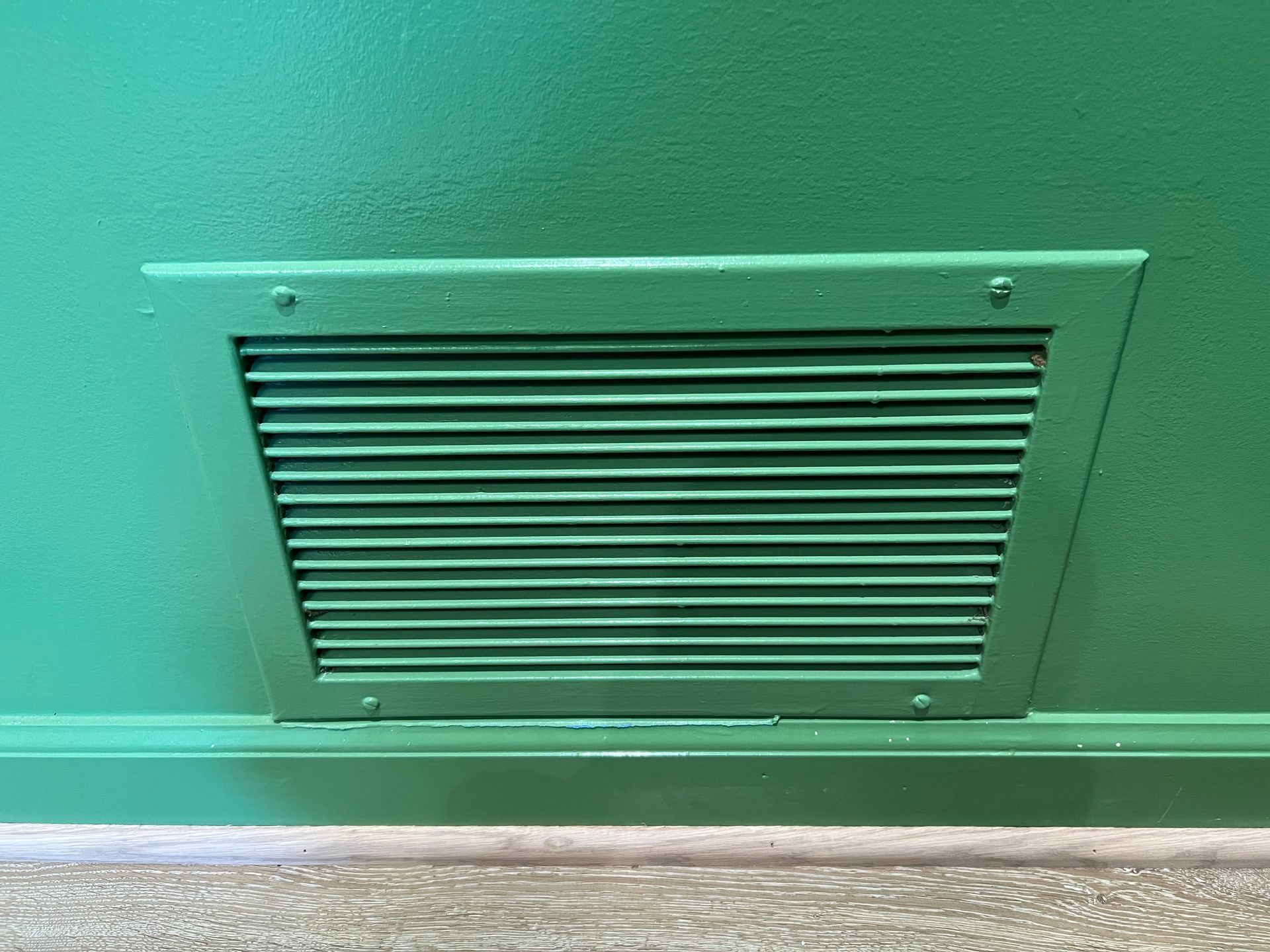Hands opening a white air vent on a white ceiling.