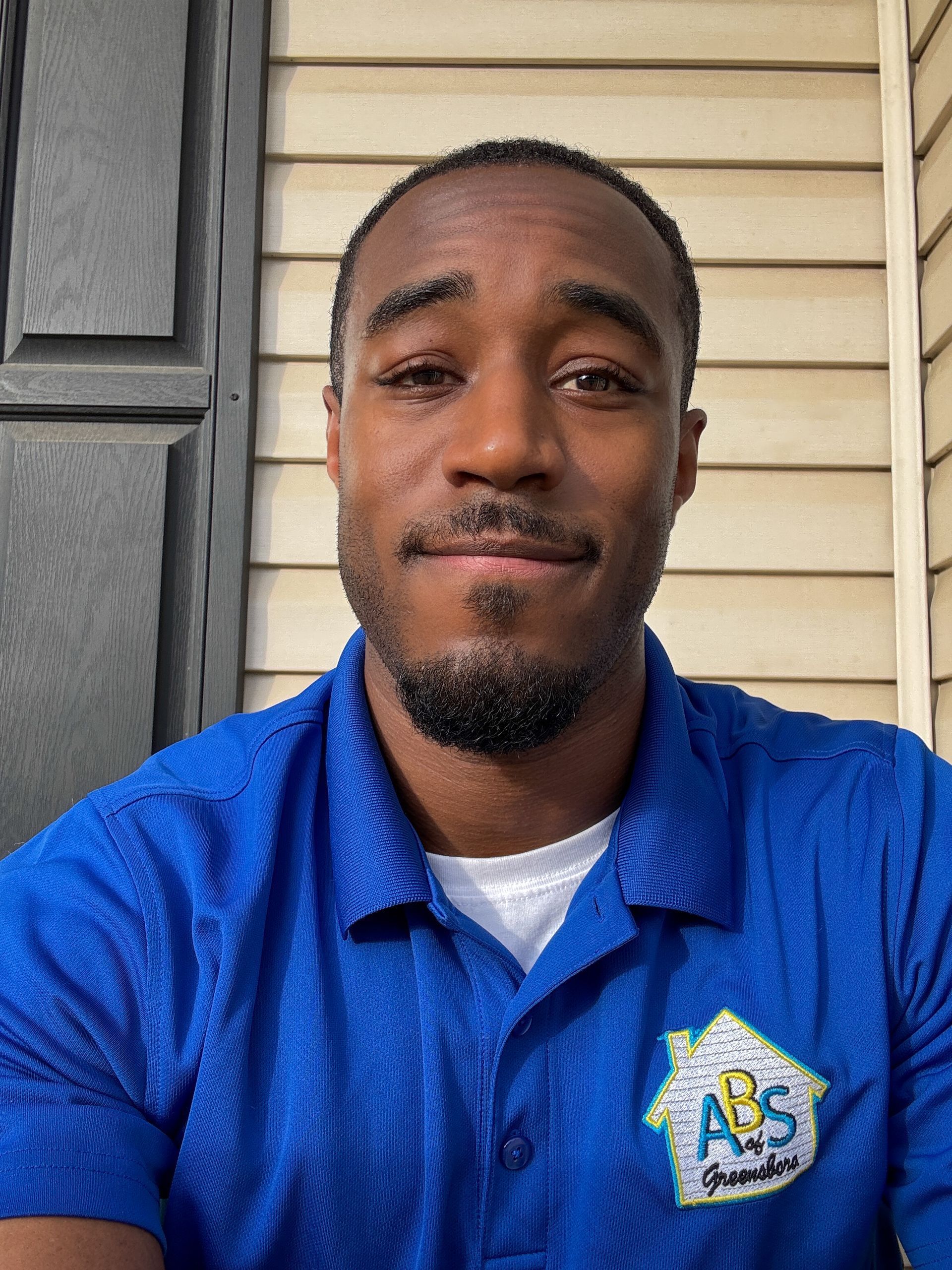 Person in blue hoodie leans near window, holding red hoop. Sunlit room, wooden trim visible.