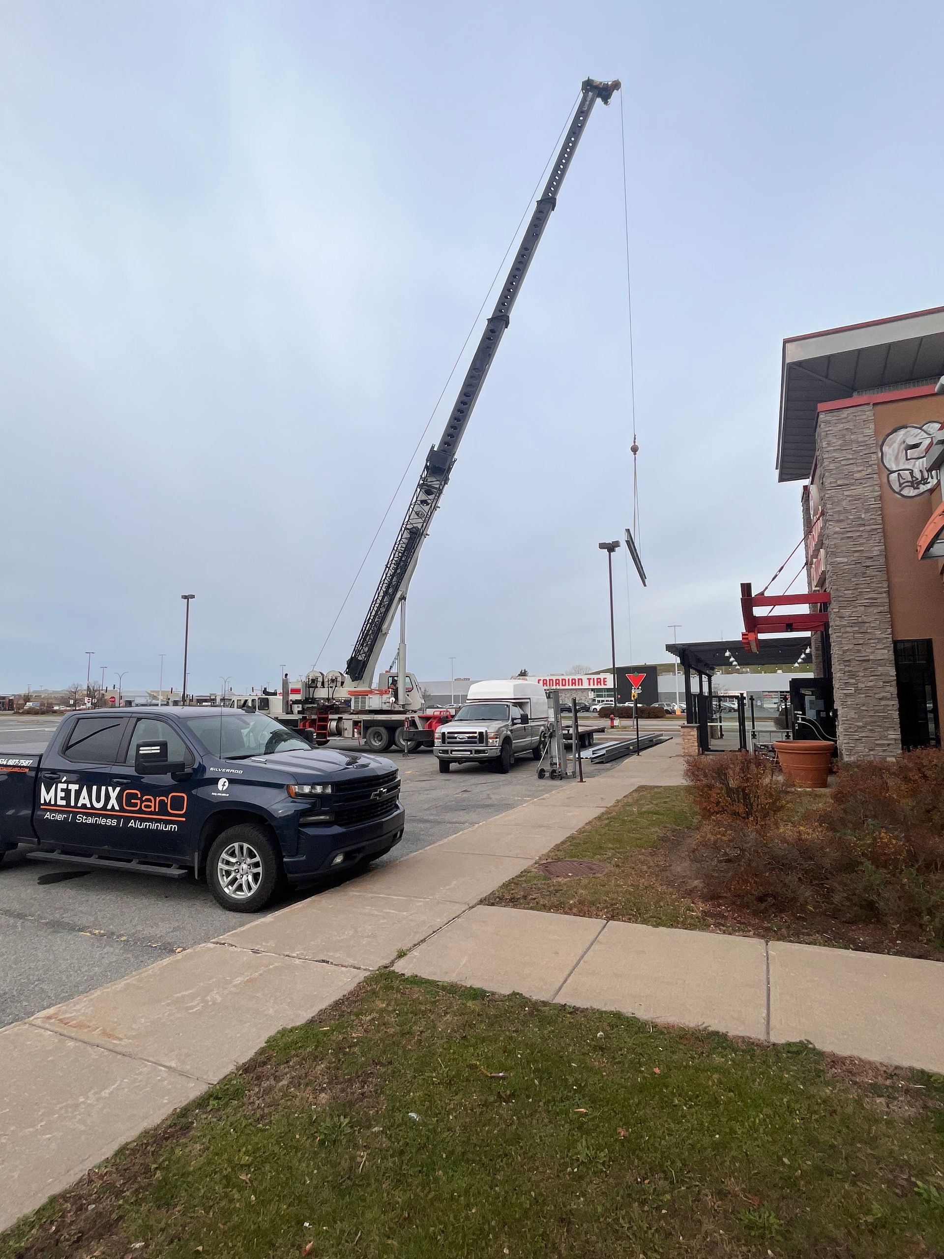 Une grande grue est installée près d'un restaurant, probablement pour des travaux de maintenance ou de construction.
