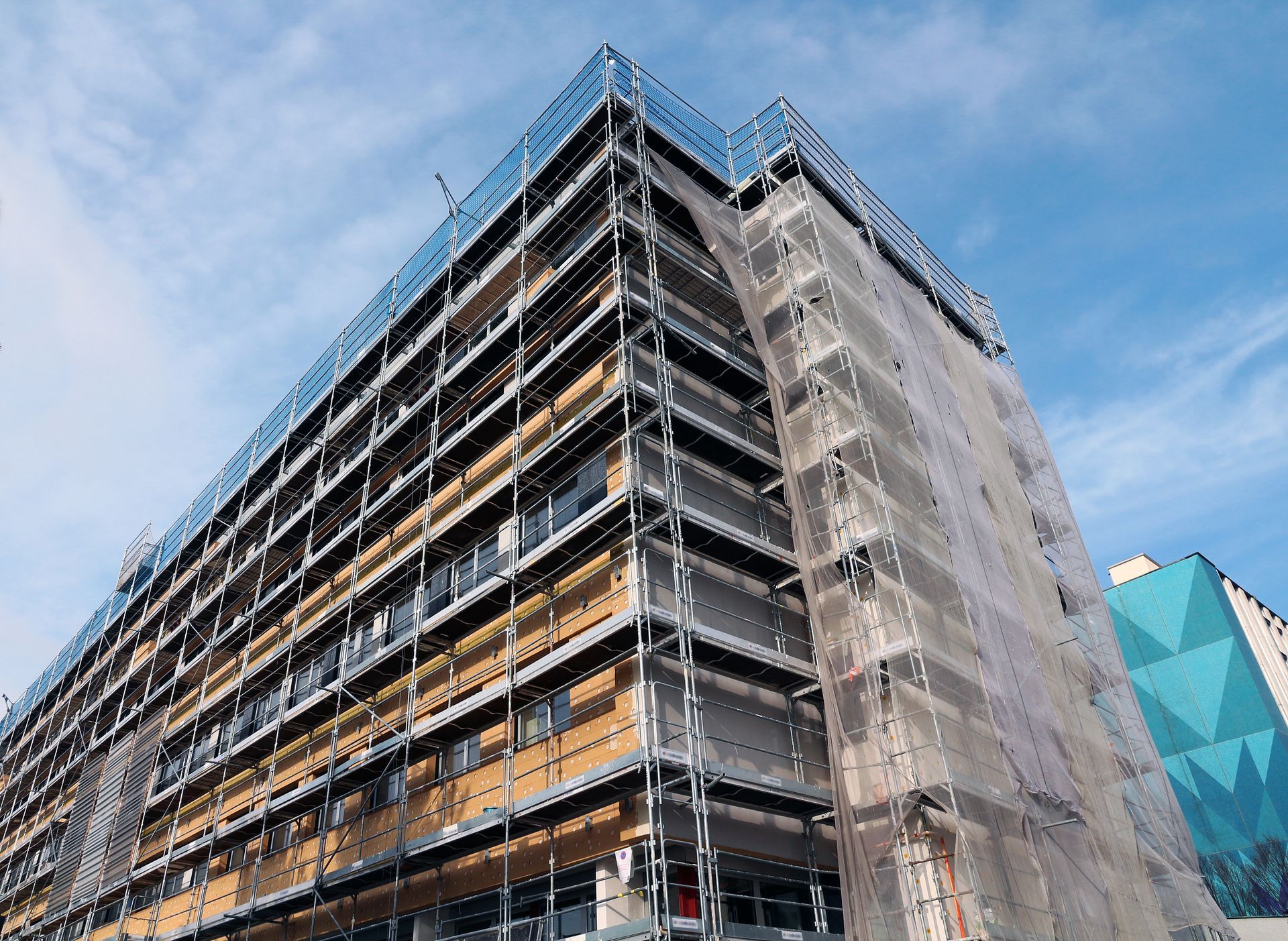 A large building under construction with scaffolding on the side.