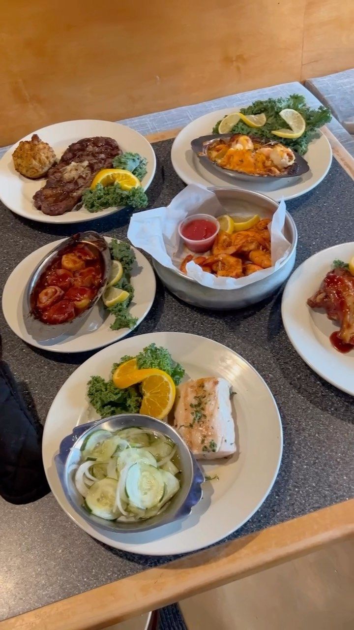 A Table Topped With Plates Of Food - Ocean Pines, MD - Don's Seafood & Chophouse