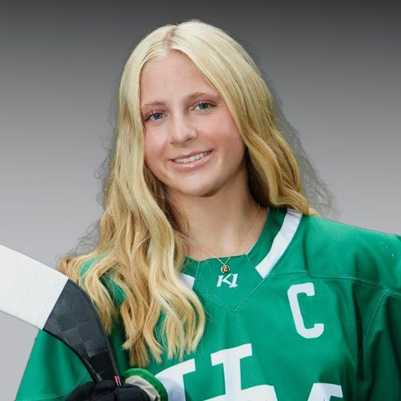 A woman wearing a green jersey with the letter c on it