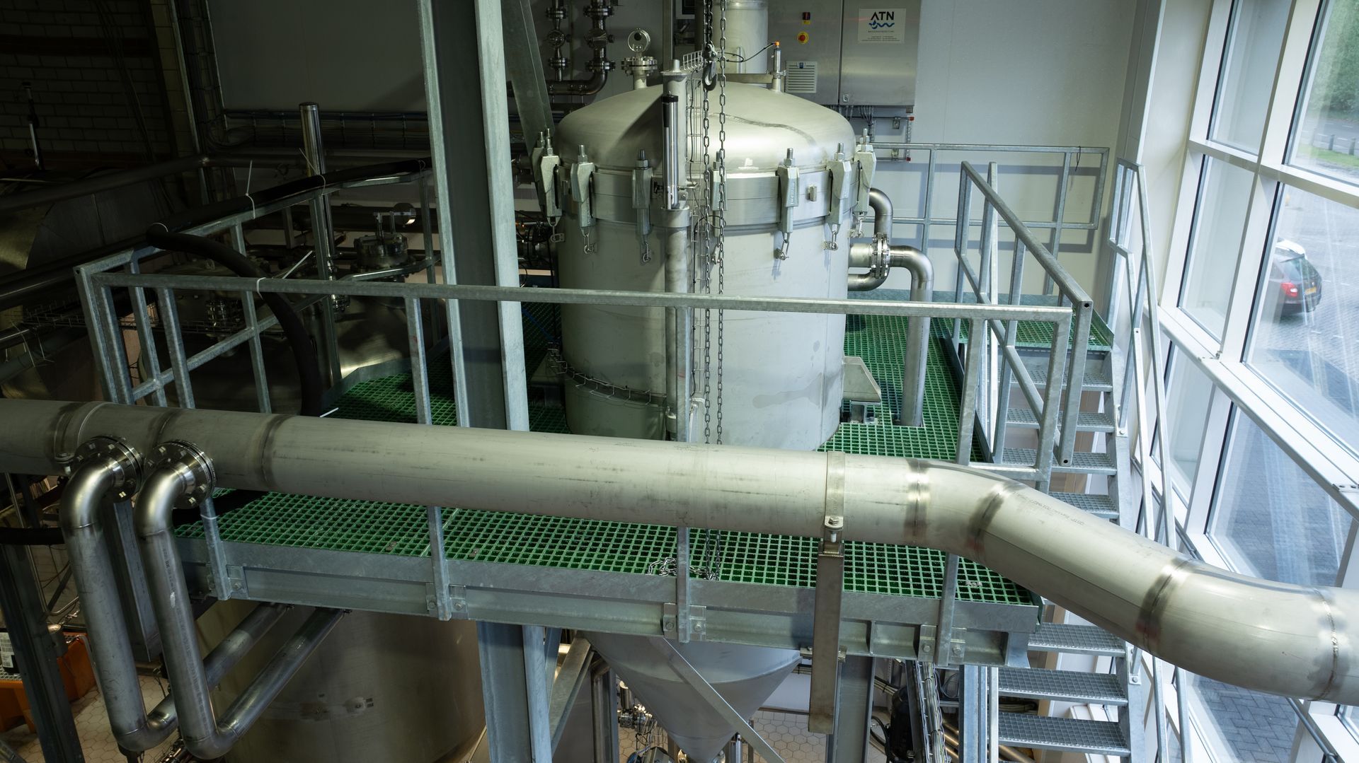 Een luchtfoto van een fabriek met pijpen en trappen