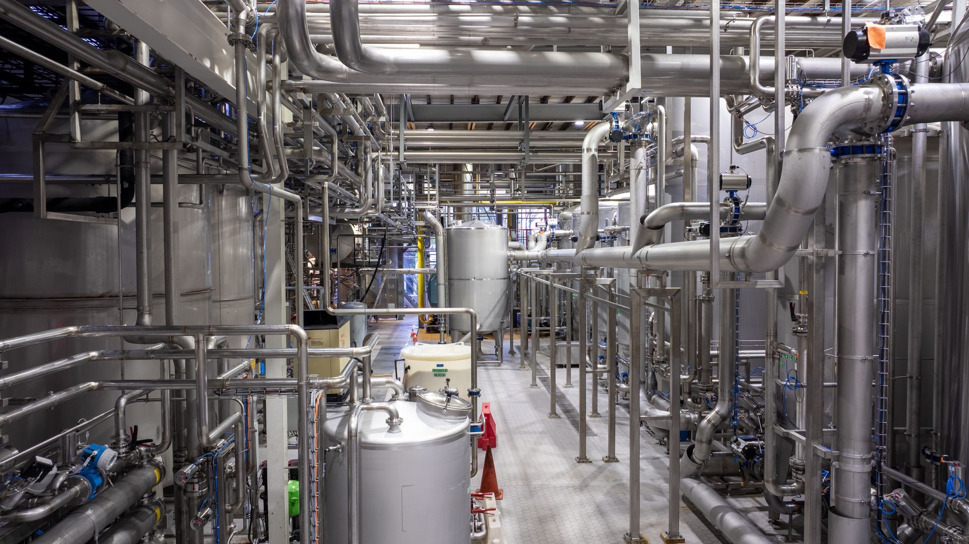 Een fabriek vol met pijpen en tanks.