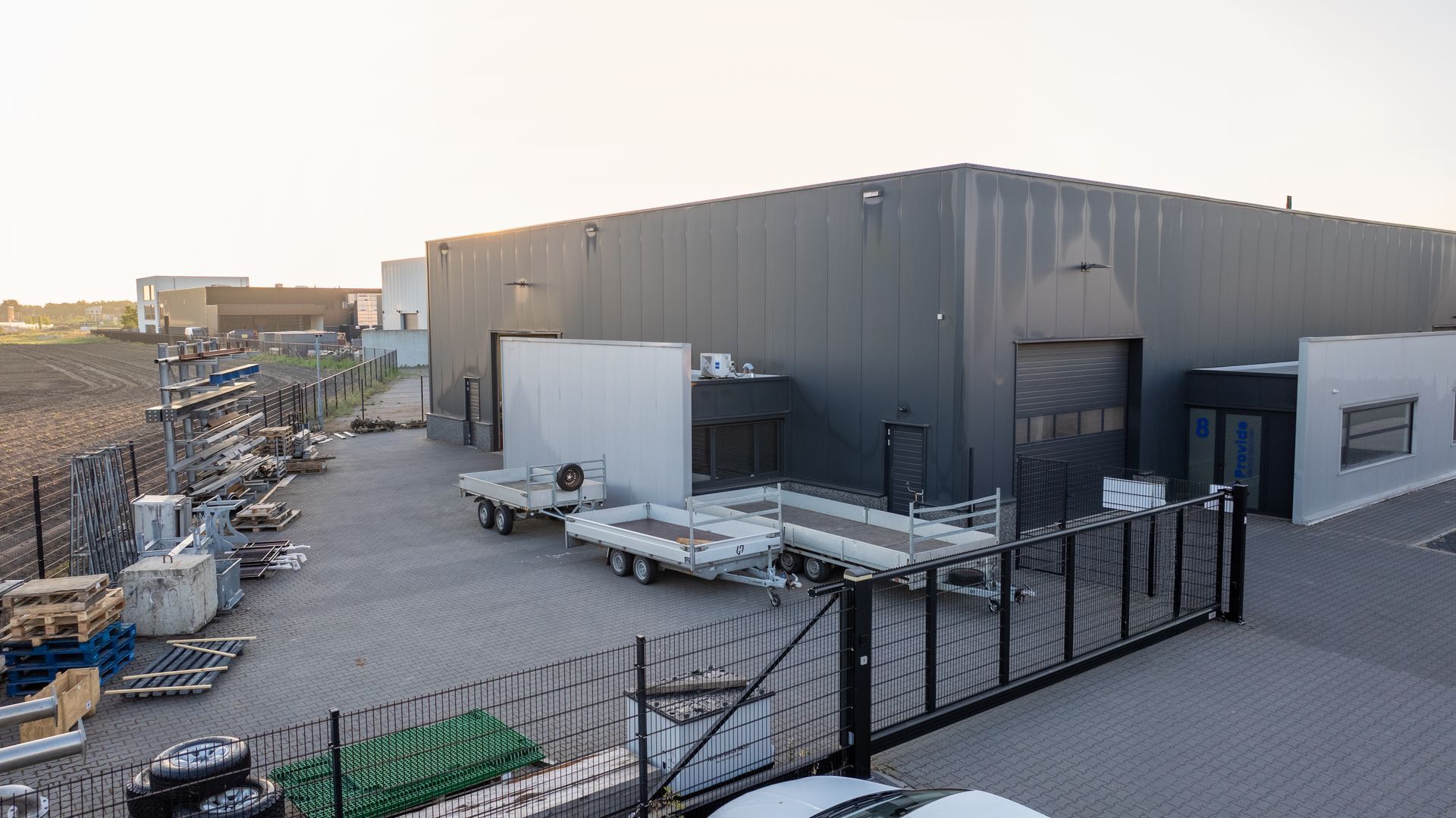 Een groot gebouw met een groot aantal trailers ervoor geparkeerd.