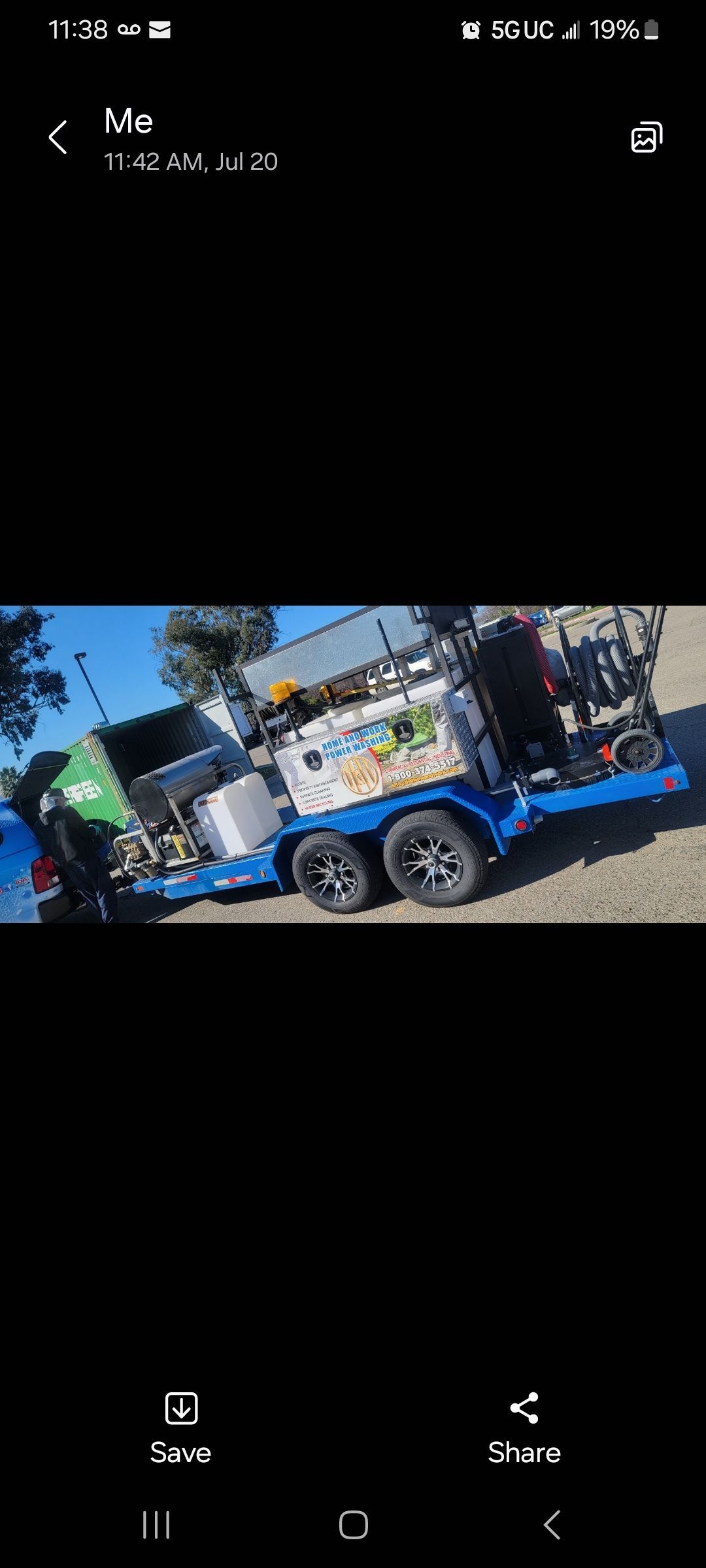 A blue trailer filled with lots of junk is parked in a parking lot.