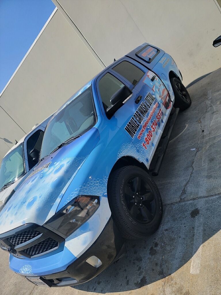A blue truck is parked on the side of the road.