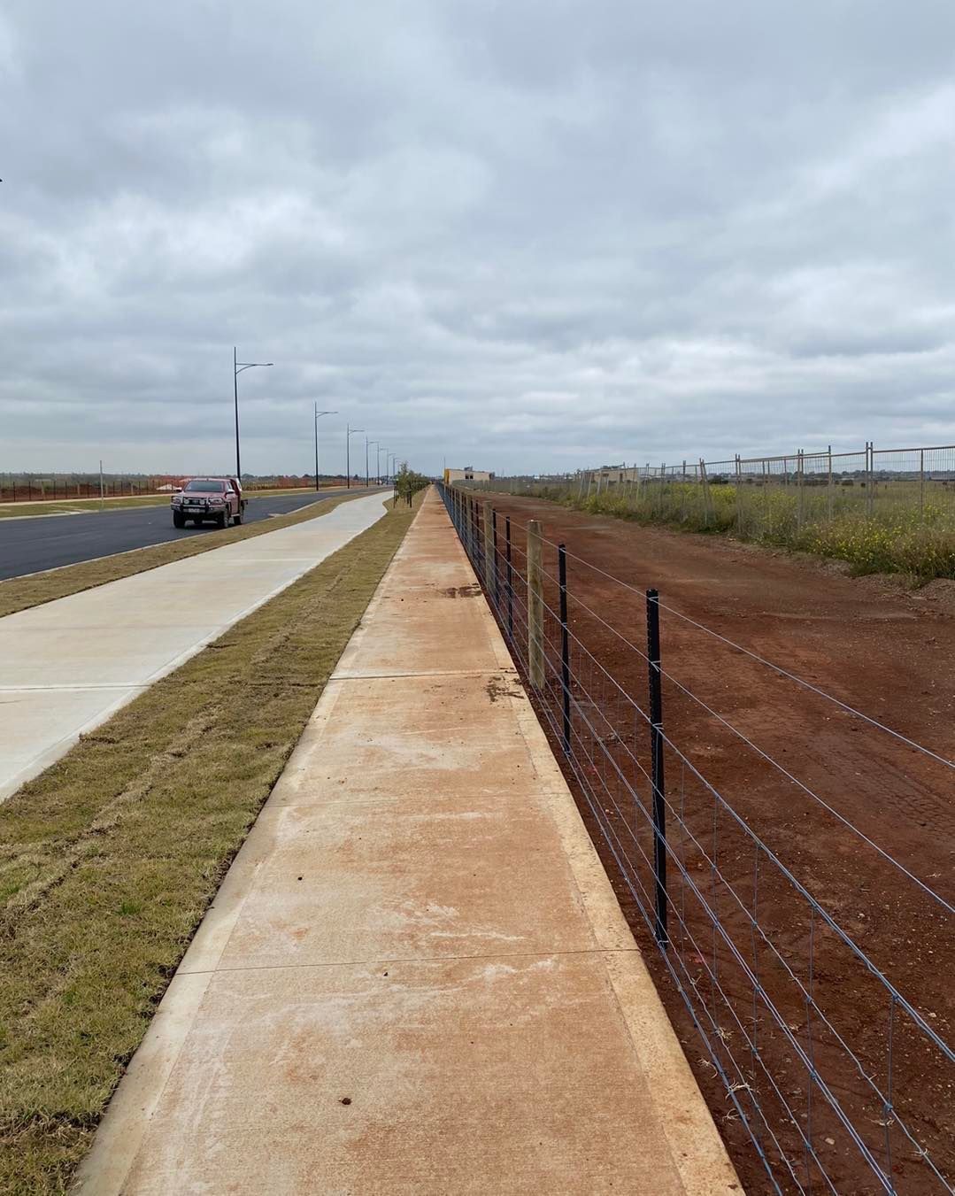 There is a fence along the side of the road.
