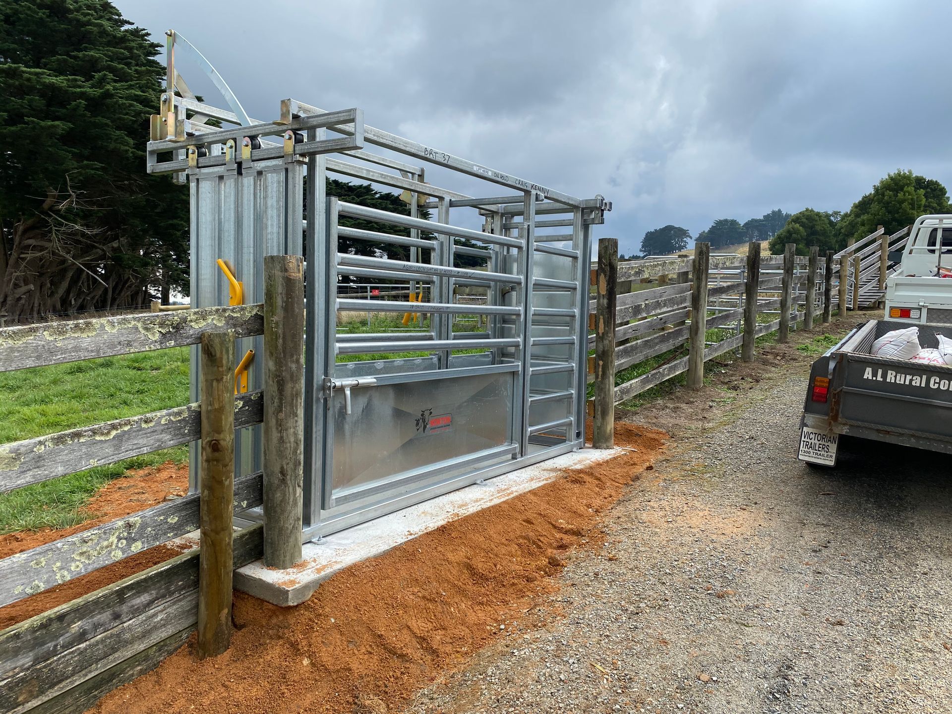 A truck is parked in front of a metal fence.