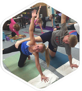 a group of people are doing yoga in a gym .