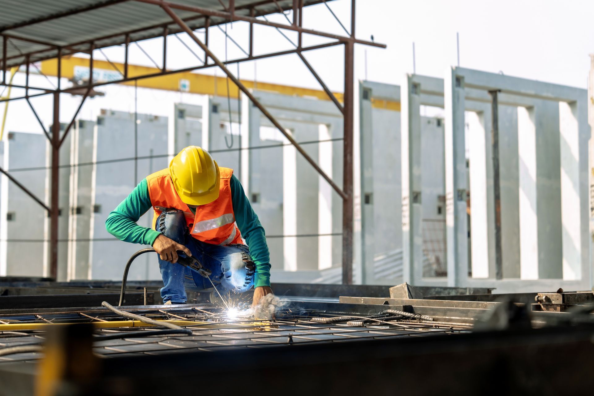 Welder working on structural steel installation at construction site, enhancing building integrity a