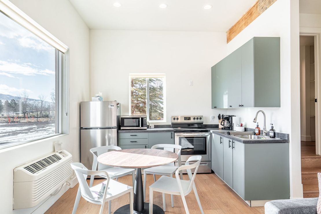 a kitchen with a table and chairs and a refrigerator .