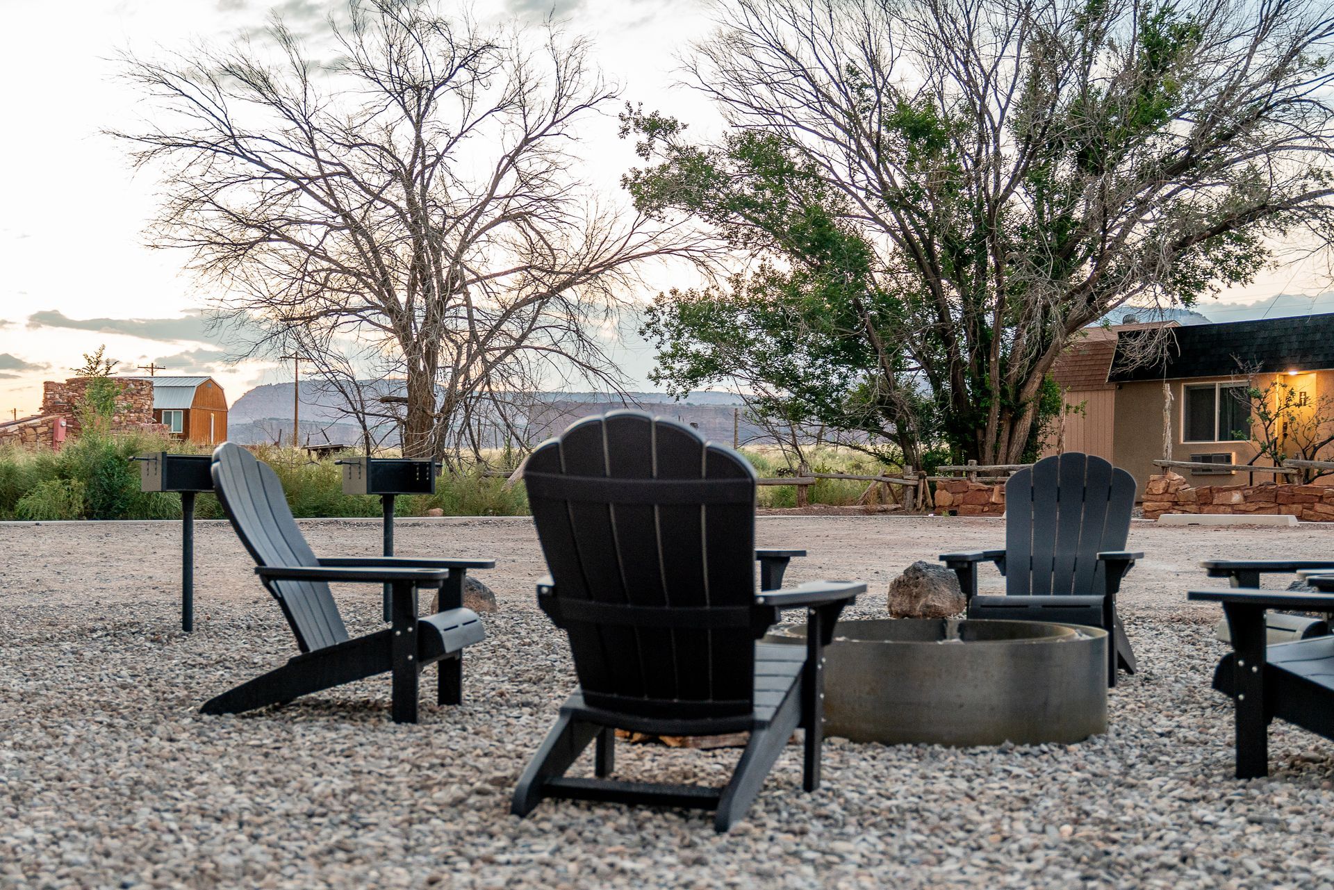 A group of chairs are sitting around a fire pit.